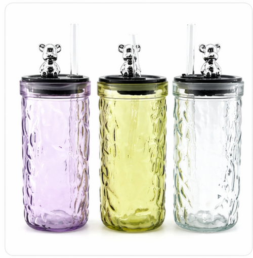 Set of colorful glass tumblers with black lids on a white background