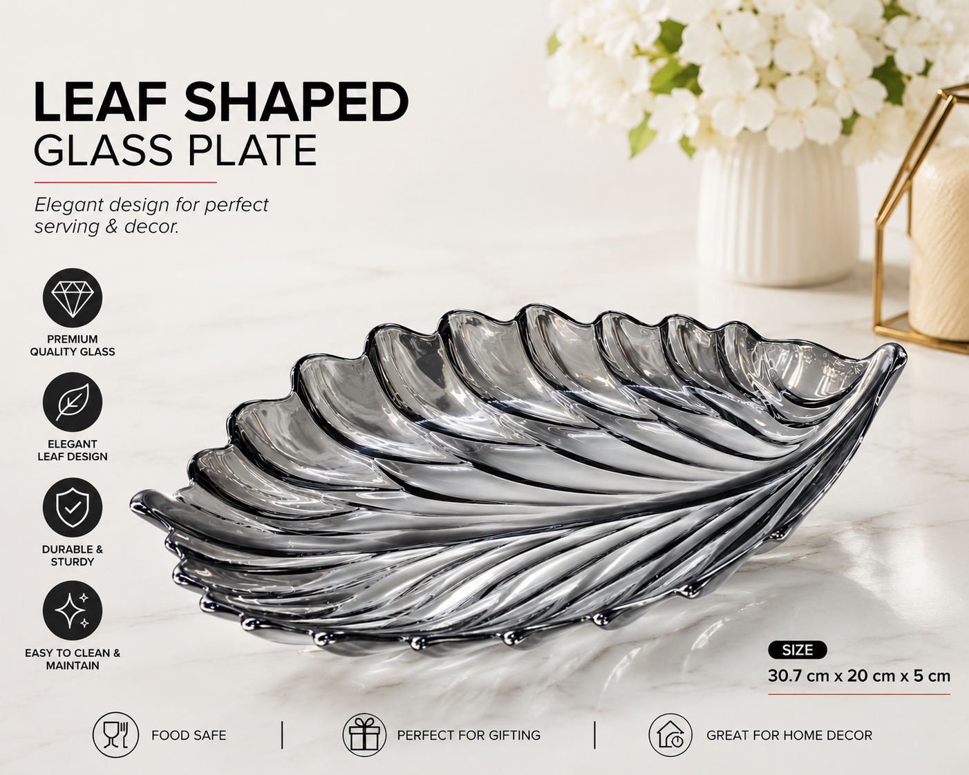 Leaf-shaped glass plate on a white surface with decorative elements